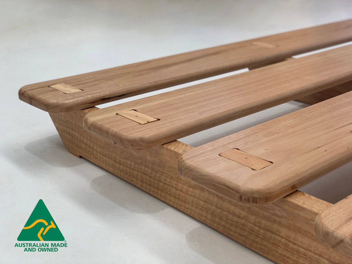 Side profile of Ark hardwood bed frame in natural timber finish