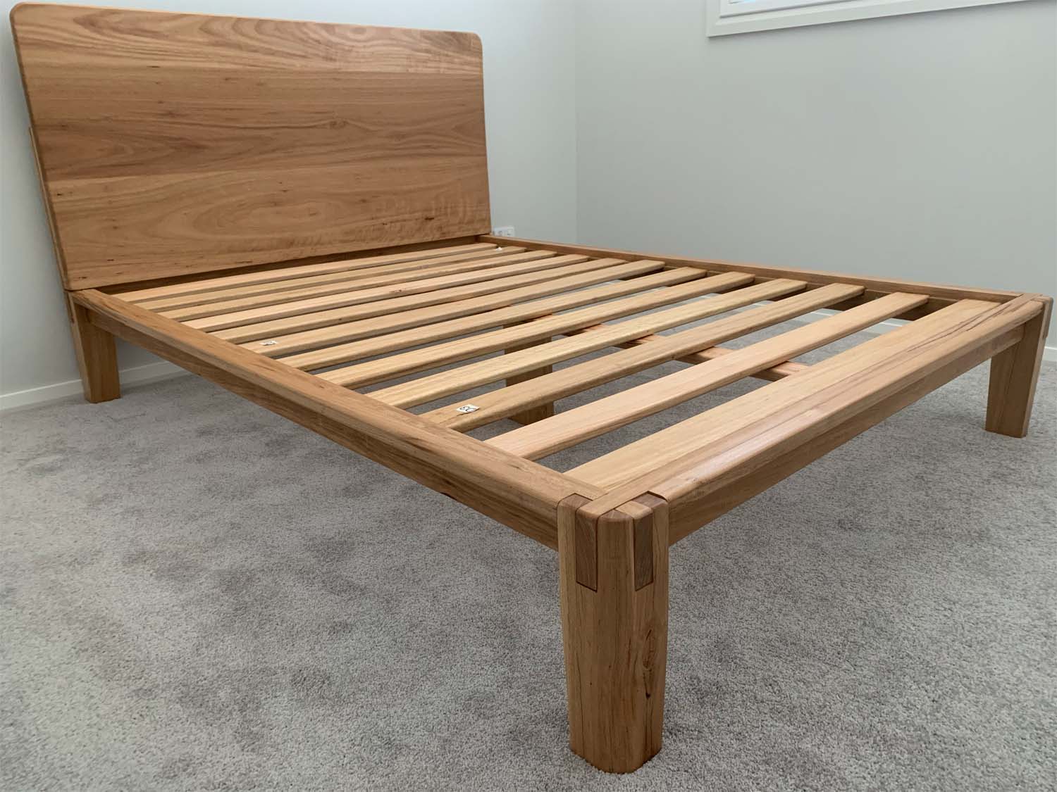 Castle Joint hardwood bed frame in real customer home with natural Blackbutt timber finish